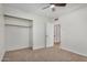 Spacious bedroom with carpet, ceiling fan, and large closet for ample storage at 8201 W Tuckey Ln, Glendale, AZ 85303