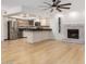 Inviting living room features an open kitchen layout, fireplace, hardwood floors, and modern ceiling fan at 8201 W Tuckey Ln, Glendale, AZ 85303