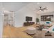 Bright, open living room featuring hardwood floors, large TV, and comfortable seating with a view to the kitchen at 8201 W Tuckey Ln, Glendale, AZ 85303
