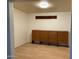 View of the light and airy living room featuring laminate flooring and built-in storage unit at 8201 W Tuckey Ln, Glendale, AZ 85303