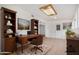 Well-lit home office featuring wooden furniture, built-in shelving, and a comfortable workspace at 8201 W Tuckey Ln, Glendale, AZ 85303