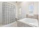 Bathroom featuring a tiled soaking tub, glass block shower and bright windows at 8310 W Daley Ln, Peoria, AZ 85383