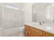 Well-lit bathroom featuring a shower-tub combination, wood vanity and large mirror at 8310 W Daley Ln, Peoria, AZ 85383