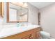 Bright bathroom with a wood vanity, modern sink, large mirror, and a tile floor at 8310 W Daley Ln, Peoria, AZ 85383