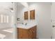Bright bathroom with wood vanity, large mirror, and ample lighting at 8310 W Daley Ln, Peoria, AZ 85383
