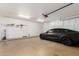 Well-organized garage featuring a sleek car, built-in storage, and efficient lighting for a modern and functional space at 8310 W Daley Ln, Peoria, AZ 85383