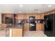Open kitchen area with oak cabinets, granite countertops, black appliances, and tile flooring at 8310 W Daley Ln, Peoria, AZ 85383