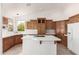 Bright kitchen with custom wood cabinets, an island, and white appliances at 8310 W Daley Ln, Peoria, AZ 85383