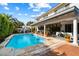 Backyard view featuring a gorgeous pool, covered patio, and lush landscaping at 8607 N Farview Dr, Scottsdale, AZ 85258