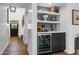 Hallway wet bar featuring a wine fridge, sink, decorative tile backsplash, and built-in shelving at 8607 N Farview Dr, Scottsdale, AZ 85258