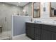 Bathroom featuring gray cabinets, double sinks, mirrors, walk-in shower, and tile floors at 8607 N Farview Dr, Scottsdale, AZ 85258