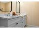 Bathroom featuring double sink vanity with gray cabinets, two mirrors and yellow striped wallpaper at 8607 N Farview Dr, Scottsdale, AZ 85258