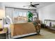 Bedroom featuring a large bed, side tables, windows with shutters, and decorative ceiling fan at 8607 N Farview Dr, Scottsdale, AZ 85258