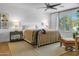 Bright bedroom features a large bed with decorative pillows, ceiling fan, and window with shutters at 8607 N Farview Dr, Scottsdale, AZ 85258