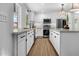 Bright kitchen featuring white cabinets, stainless appliances, modern light fixtures and light wood flooring at 8607 N Farview Dr, Scottsdale, AZ 85258