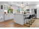 Bright kitchen featuring white cabinets, an island with bar seating, modern light fixtures and stainless appliances at 8607 N Farview Dr, Scottsdale, AZ 85258