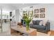 Bright living room featuring a stylish gray sofa, decorative artwork, and a light wood coffee table at 8607 N Farview Dr, Scottsdale, AZ 85258