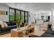 Open-concept living room with black framed doors, light hardwood floors, and a view of the kitchen at 8607 N Farview Dr, Scottsdale, AZ 85258