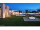 Expansive backyard featuring manicured lawn, modern fire pit, and a sleek outdoor bar and seating area at 10220 N 66Th St, Paradise Valley, AZ 85253