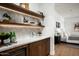 Chic bar area featuring a wine fridge, white marble counter, and decorative shelves with stylish decor at 10220 N 66Th St, Paradise Valley, AZ 85253