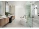 Bright bathroom features double vanities, standalone tub, and glass-enclosed shower with marble tiling and modern fixtures at 10220 N 66Th St, Paradise Valley, AZ 85253