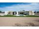 Stunning modern home featuring a large front yard, desert landscaping, and a sleek in-ground pool at 10220 N 66Th St, Paradise Valley, AZ 85253