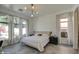 Bright bedroom featuring large windows, tile floors, and designer lighting fixture at 14132 W Bent Tree S Cir, Litchfield Park, AZ 85340