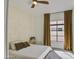Well-lit bedroom with ceiling fan, neutral colors, and large window with curtains at 14132 W Bent Tree S Cir, Litchfield Park, AZ 85340