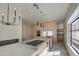 Modern kitchen with a large island, stainless steel appliances, and views of the living area at 14132 W Bent Tree S Cir, Litchfield Park, AZ 85340