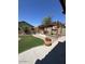 Landscaped backyard featuring a covered patio, a built-in grill, and a paved walkway at 16336 N 168Th Ave, Surprise, AZ 85388