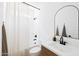 Well-lit bathroom featuring a shower with neutral shower curtain, a modern vanity, and sleek black fixtures at 17816 W Oregon Ave, Litchfield Park, AZ 85340