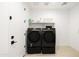 Functional laundry room featuring modern black appliances, floating shelves, and a clean, organized design at 17816 W Oregon Ave, Litchfield Park, AZ 85340
