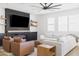 Modern living room with stylish furniture, a ceiling fan, a large TV, and an electric fireplace for cozy evenings at 17816 W Oregon Ave, Litchfield Park, AZ 85340