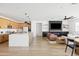Spacious living space with an open kitchen, dining area, and a cozy living room with TV, creating a welcoming atmosphere at 17816 W Oregon Ave, Litchfield Park, AZ 85340