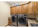 Laundry room with granite countertops, sink, wooden cabinets, and a washer and dryer at 1815 W Maddock Rd, Phoenix, AZ 85086