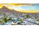 Aerial view capturing a neighborhood with a mountain backdrop, homes featuring sparkling pools, lush landscaping at 1955 E Greenway Rd, Phoenix, AZ 85022