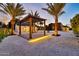 Well-lit backyard featuring desert landscaping, a modern gazebo, and multiple buildings at 1955 E Greenway Rd, Phoenix, AZ 85022