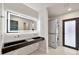 Modern bathroom with double sink vanity, a light-up mirror, and a stacked washer/dryer at 1955 E Greenway Rd, Phoenix, AZ 85022