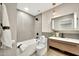 Bathroom featuring a sleek design with a modern vanity, toilet, and tiled tub and shower at 1955 E Greenway Rd, Phoenix, AZ 85022