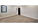 Open bedroom with hardwood floors, neutral walls, and a black door leading to another room at 1955 E Greenway Rd, Phoenix, AZ 85022
