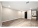 Neutral room with wood floors and a view to living room through a black paneled door at 1955 E Greenway Rd, Phoenix, AZ 85022