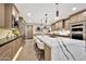 Modern kitchen featuring an island with a waterfall countertop, stainless steel appliances, and custom cabinetry at 1955 E Greenway Rd, Phoenix, AZ 85022