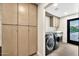 Well-equipped laundry room with modern machines and ample cabinet space at 1955 E Greenway Rd, Phoenix, AZ 85022