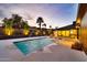 Backyard pool features elegant fountains, sleek patio, and lush landscaping at sunset at 1955 E Greenway Rd, Phoenix, AZ 85022