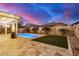 Relaxing backyard with travertine pavers, a lush lawn, and desert landscaping at 20552 E Reins Rd, Queen Creek, AZ 85142