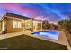 Spacious backyard featuring a covered patio, pool, spa, and artificial turf at 20552 E Reins Rd, Queen Creek, AZ 85142