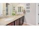 Bathroom vanity with dual sinks, granite countertop, dark wood cabinets, and decorative wall accents at 20552 E Reins Rd, Queen Creek, AZ 85142