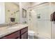Granite vanity and glass shower with a neutral color palette create a relaxing bathroom at 20552 E Reins Rd, Queen Creek, AZ 85142