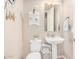 Charming half bathroom with a pedestal sink, decorative shelving, and beach-themed decor at 20552 E Reins Rd, Queen Creek, AZ 85142