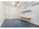 Clean garage features a painted floor, workspace and shelving for storage at 20552 E Reins Rd, Queen Creek, AZ 85142